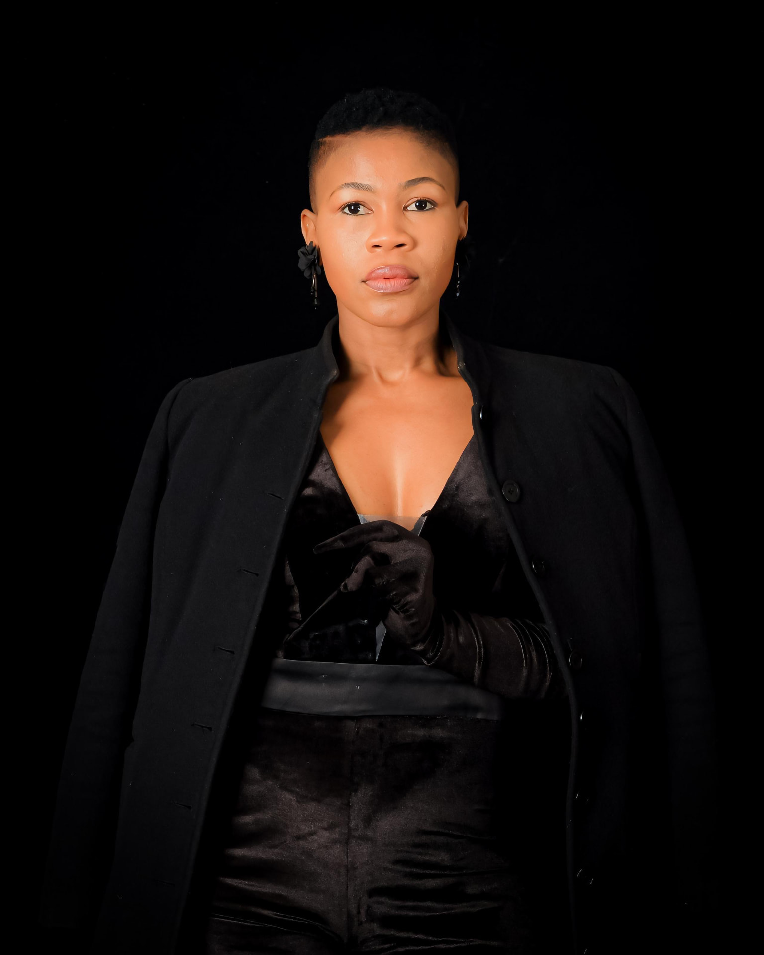 Swazi Mokeona in an all-black velvet outfit with gloves, studio portrait