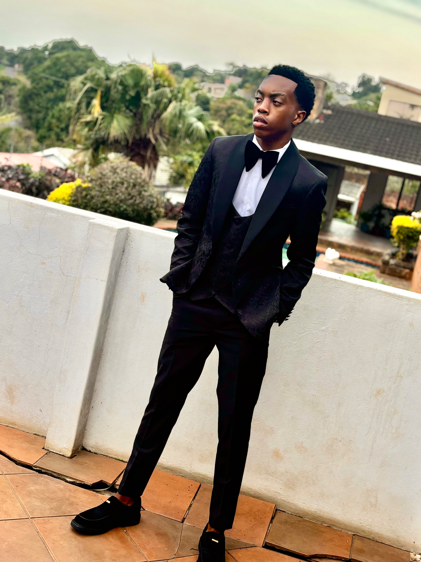 Sipho Biyela in a black tuxedo on a balcony overlooking Durban