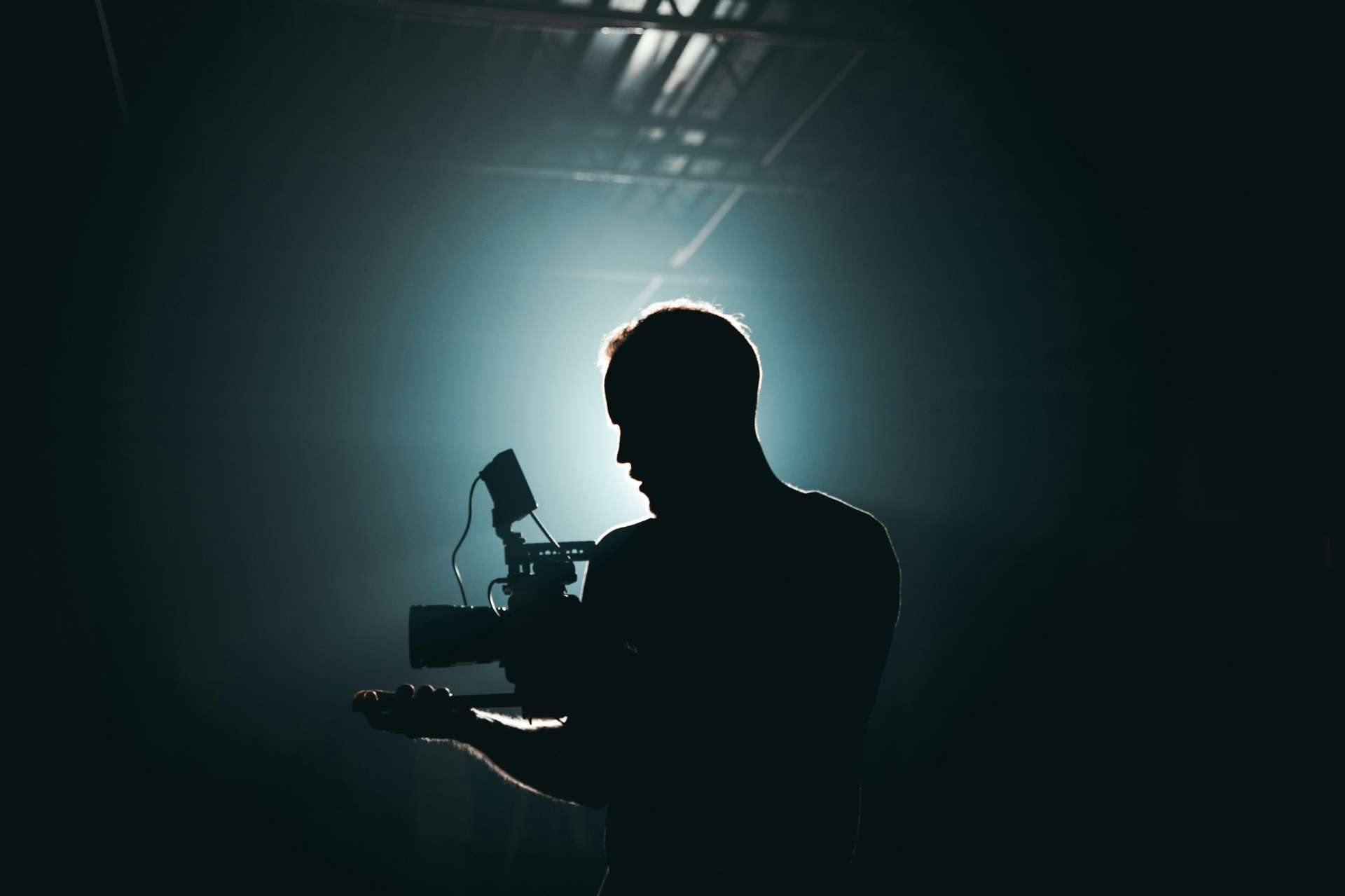 Cinematographer silhouetted against dramatic backlit haze on a film set