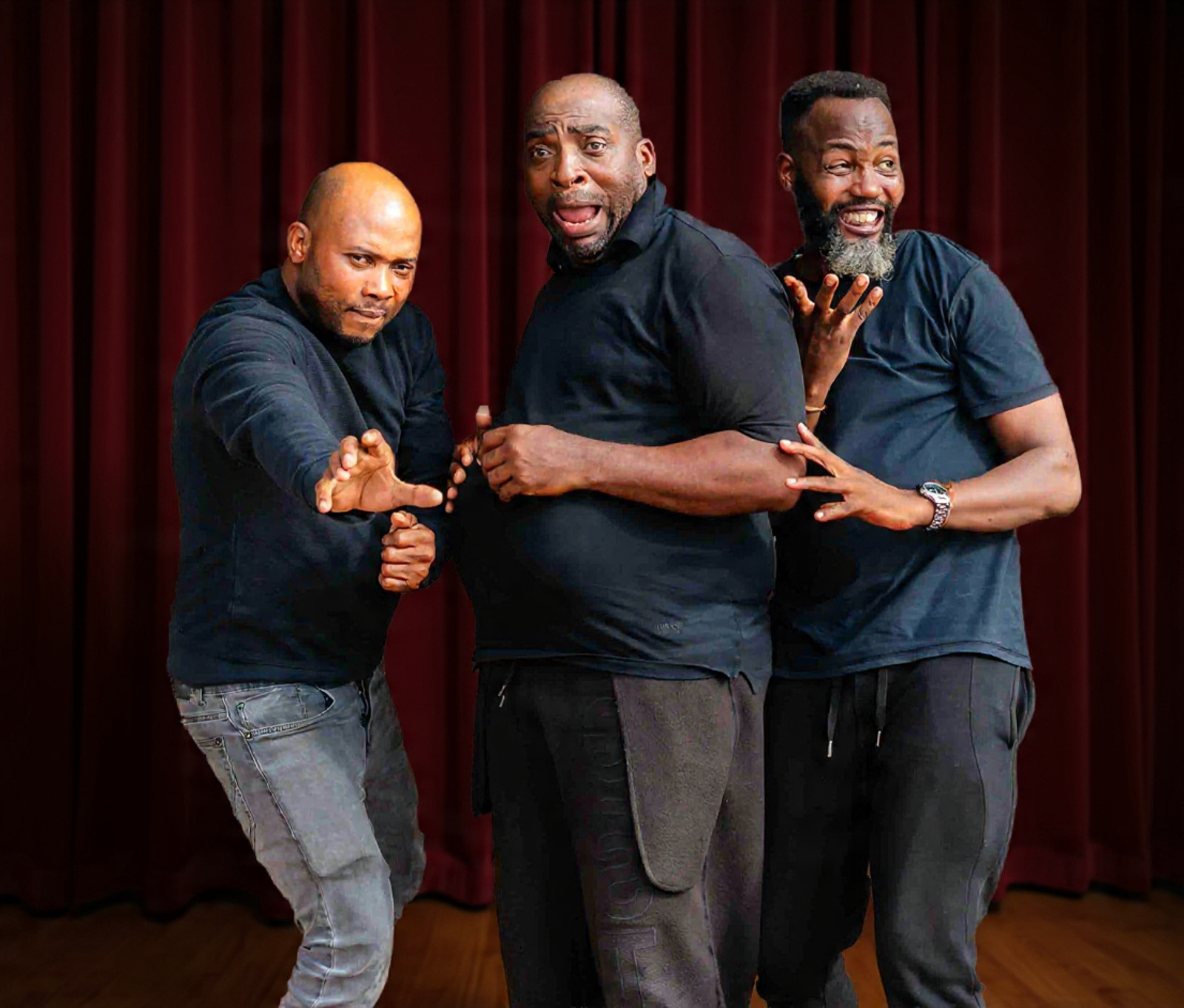 Three Properlymade performers in character on a stage with red curtains